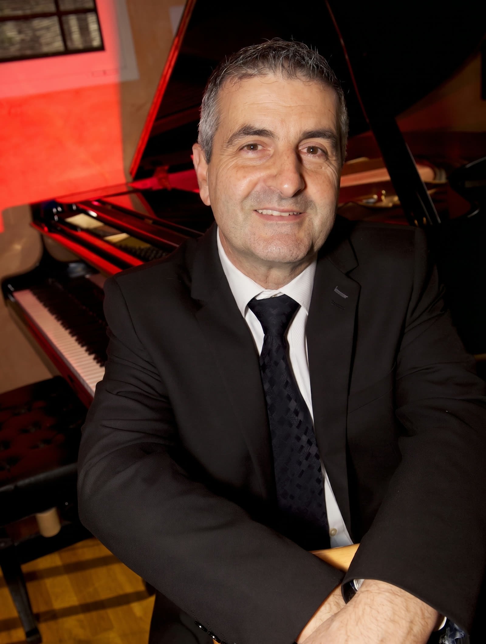 Claude Tedesco devant son piano à queue
